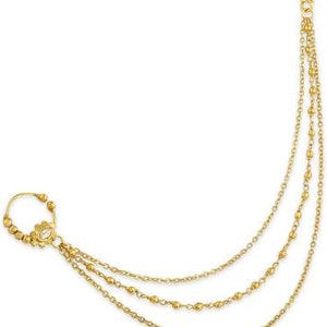 May include: Gold nose ring with a chain that hangs down the side of the face. The chain has three strands of small gold beads.