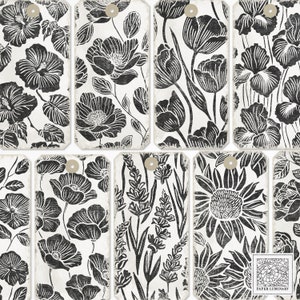 May include: Nine black and white printable gift tags with floral designs. The tags feature various flowers, including poppies, tulips, sunflowers, and lavender. The tags have a distressed, vintage look.