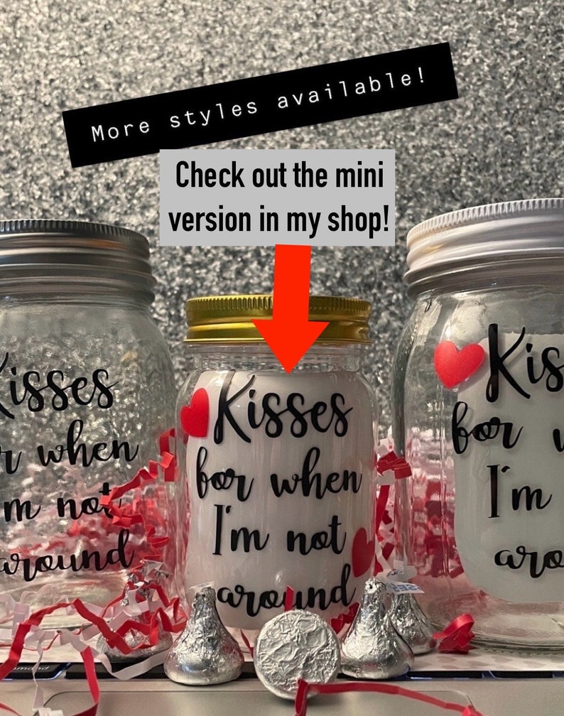 May include: Three glass mason jars with metal lids, each decorated with red hearts and the phrase "Kisses for when I'm not around" in black script. Hershey's Kisses and a silver coin are in front of the jars. Text in the image says "More styles available!" and "Check out the mini version in my shop!"