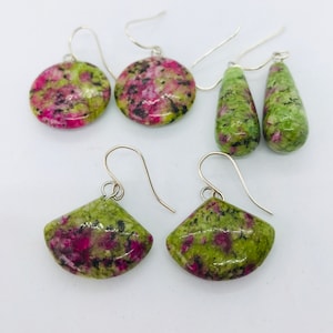 May include: A set of four earrings featuring green and pink gemstone drops. The earrings are made of silver and have a variety of shapes, including round and teardrop.