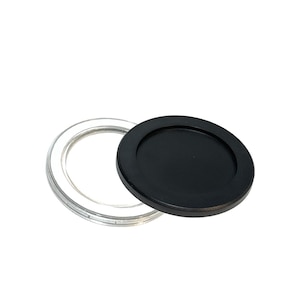 May include: A clear, circular coaster with a transparent rim and a separate, solid black coaster. The black coaster is round and slightly raised, designed to sit inside the clear rim. The items are set against a white background.
