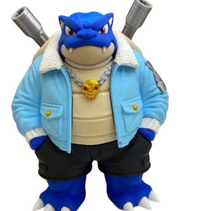 May include: A blue turtle-like creature figure wearing a light blue jacket with a white faux-fur collar, black shorts, and a silver chain necklace with a gold skull pendant. Two metallic grey cannons protrude from the back of the shell.