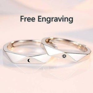 May include: Two silver rings with geometric designs. One ring features a crescent moon and the other features a sun.