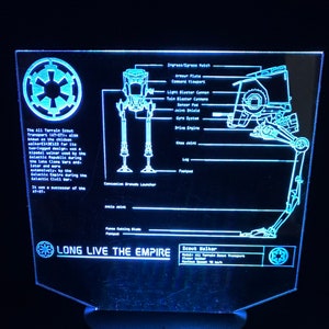 May include: A blue and white light-up sign with a diagram of a Star Wars AT-ST walker. The sign reads "LONG LIVE THE EMPIRE" and includes a diagram of the walker with labels for its parts. The sign also features the Star Wars Imperial logo.