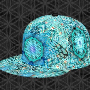 May include: A blue and teal baseball cap with a geometric and floral pattern. The cap has a black brim and a black button on top. The design includes various geometric shapes and symbols.