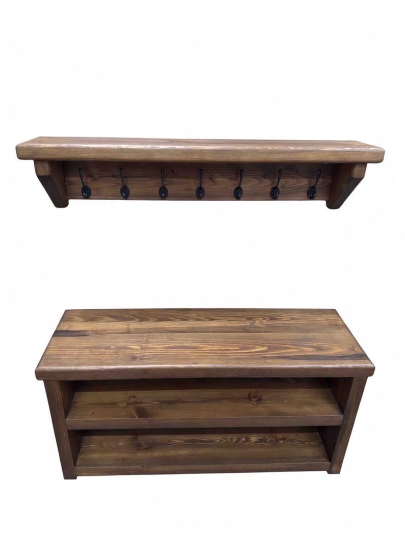 Puede incluir: Un perchero de pared de madera marr&oacute;n oscuro con siete ganchos de metal negro y un banco de madera rectangular a juego con dos estantes de almacenamiento abiertos. Ambas piezas muestran una textura de veta de madera visible y un acabado te&ntilde;ido.