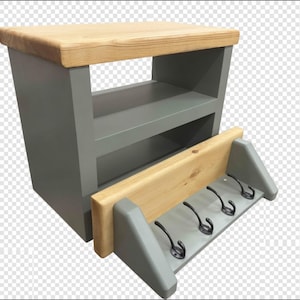 Puede incluir: Una unidad de almacenamiento de madera gris con una superficie superior de madera clara natural y un estante abierto. En la parte frontal hay una secci&oacute;n inferior de madera gris con un borde superior de madera clara y cuatro ganchos de metal negro.