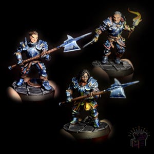 May include: Three miniature figures of warriors wearing blue and silver armor, each holding a weapon. The figures are posed in a fighting stance and are set on circular bases.