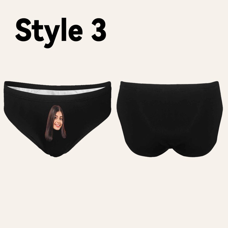 Op de afbeelding: Zwarte onderbroek met een witte tailleband. De voorkant van de onderbroek heeft een geprinte afbeelding van een vrouwen gezicht.