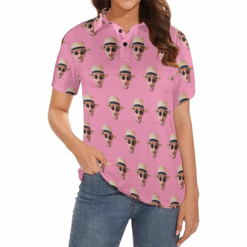 May include: A pink polo shirt with a repeating pattern of a person's face wearing a straw hat and sunglasses.