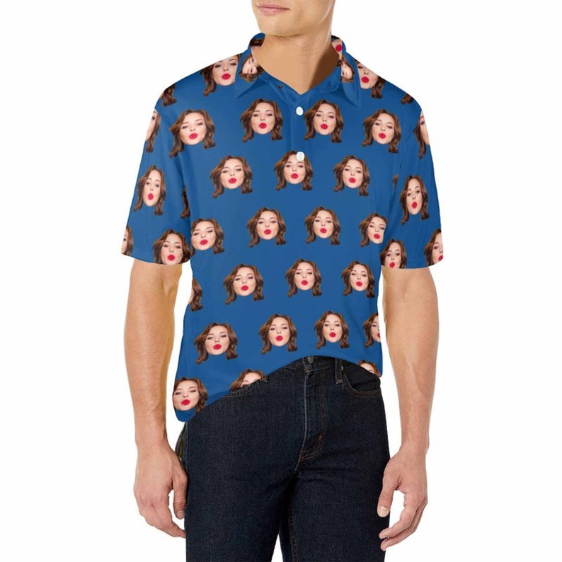 May include: A blue short-sleeved polo shirt with a repeating pattern of a woman's face. The woman is wearing red lipstick and has brown hair.