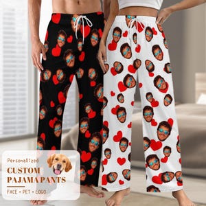 Pode incluir: Um par de calças de pijama preto e branco com um padrão de coração e rosto. O texto "Personalized Custom Pajama Pants Face - Pet - Logo" está na imagem.