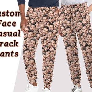 May include: Custom face casual track pants with a repeating pattern of a man's face. The pants are a light brown color and have a drawstring waistband.