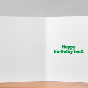 May include: A blank white card with a green greeting that reads "Happy birthday bud!"