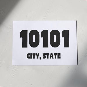 Può includere: Un cartello rettangolare bianco con il testo nero "10101" sopra "CITY, STATE". I numeri sono in grassetto, carattere sans-serif. Il testo "CITY, STATE" è anch'esso in grassetto, carattere sans-serif.
