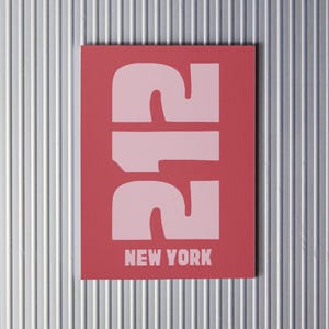 Puede incluir: Una tarjeta roja con el número 212 en letras grandes de color rosa y las palabras "NEW YORK" en letras rosas más pequeñas.