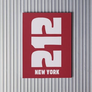 Puede incluir: Una tarjeta roja con el número 212 en blanco, en negrita. El texto "NEW YORK" está impreso en blanco debajo del número.