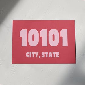 Può includere: Un cartello rettangolare rosso con il numero 10101 stampato in rosa e il testo "CITY, STATE" stampato in rosa sotto il numero.