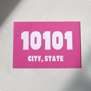 Può includere: Poster rosa con il numero 10101 in testo bianco e le parole "CITY, STATE" in testo bianco sotto il numero.