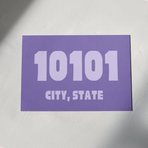 Può includere: Un poster viola con il numero 10101 stampato in bianco e il testo "CITY, STATE" sotto.