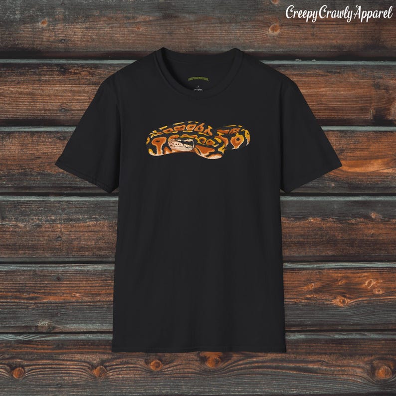 May include: Black t-shirt with a graphic print of a brown and yellow snake.