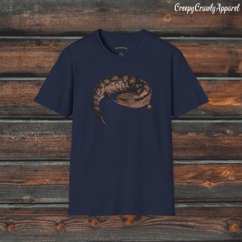 May include: A navy blue t-shirt with a brown and black lizard graphic. The lizard is curled up in a ball and has a blue tongue.