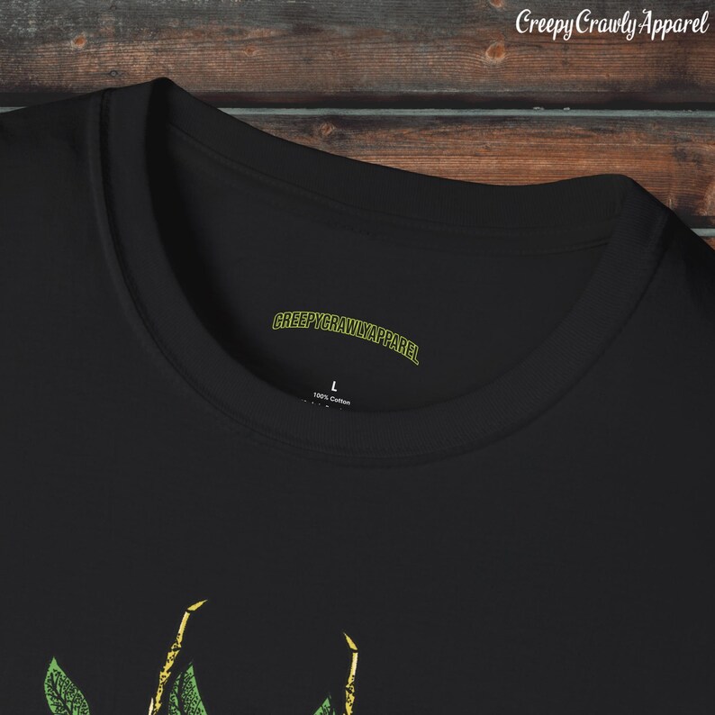 May include: Black t-shirt with a green and yellow graphic of a praying mantis. The shirt has a tag that says "CreepyCrawlyApparel" and "100% Cotton".