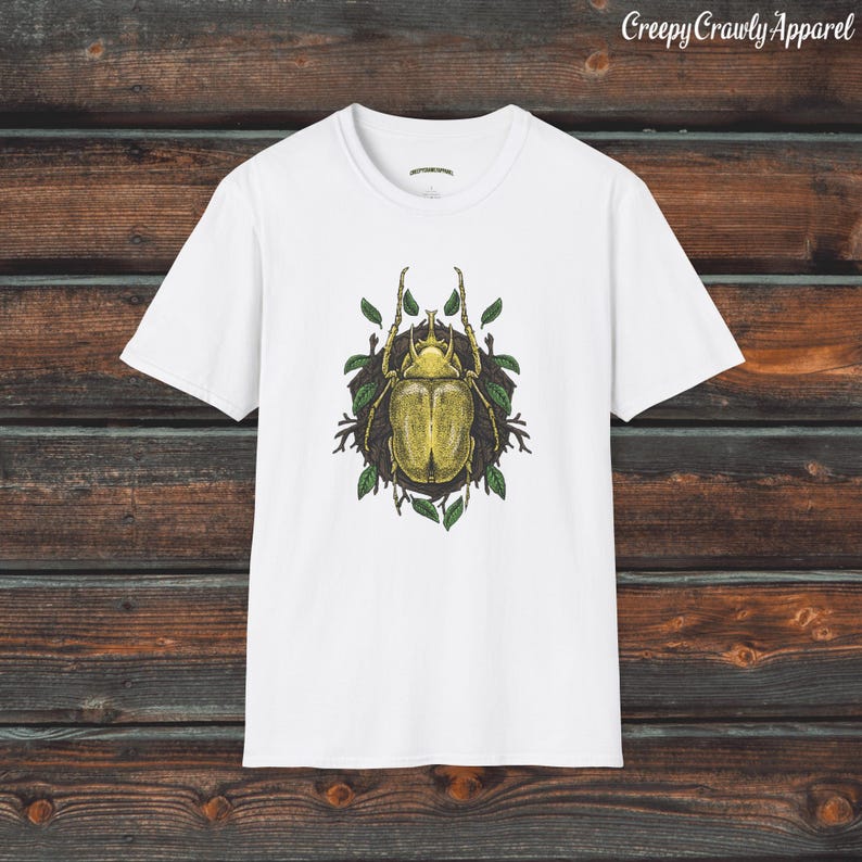 May include: White t-shirt with a graphic print of a green beetle surrounded by leaves.