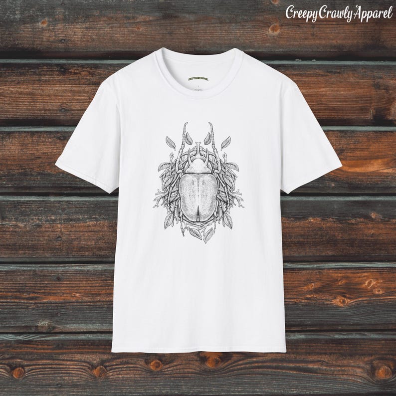 Op de afbeelding: Wit T-shirt met een zwart-witte illustratie van een kever omringd door bladeren.