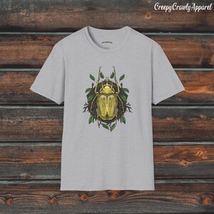 May include: A grey t-shirt with a graphic of a yellow beetle surrounded by green leaves. The text "Creepy Crawly Apparel" is at the top of the image.