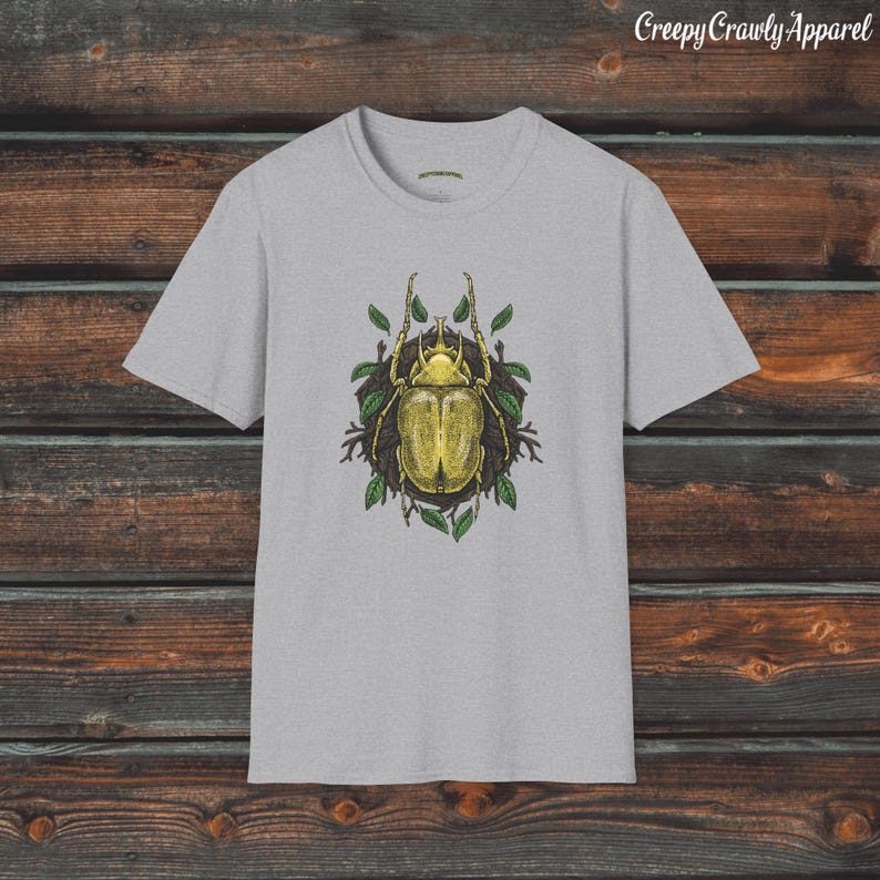 May include: A grey t-shirt with a graphic of a yellow beetle surrounded by green leaves. The text "Creepy Crawly Apparel" is at the top of the image.