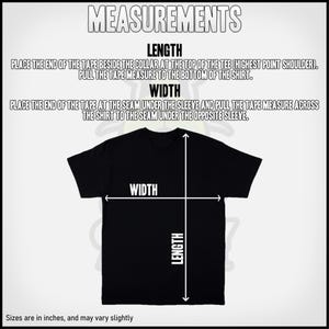 Op de afbeelding: Diagram met instructies voor het meten van de lengte en breedte van een T-shirt. Plaats het uiteinde van de meetlint bij de kraag en trek het naar de onderkant van het shirt om de lengte te meten. Plaats het uiteinde van de meetlint bij de naad onder de mouw en trek het over het shirt naar de naad onder de andere mouw om de breedte te meten. De maten zijn in inches en kunnen enigszins vari&euml;ren.