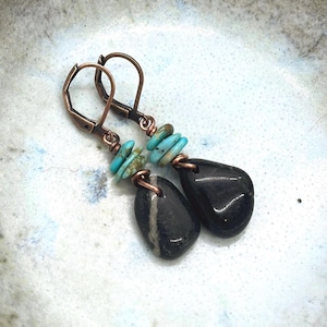 May include: A white ceramic mug with a black handle and the text "But First, Coffee" in a black, bold font. The mug is on a white surface.