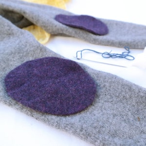 Pair of upcycling wool felt patches for repairing wool clothing in purple oval shape