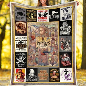 May include: A plush, cream-colored blanket featuring a collage of imagery from the movie "The Princess Bride." The design includes character portraits, quotes, and iconic scenes, with a gold border. The blanket is held up by a person.
