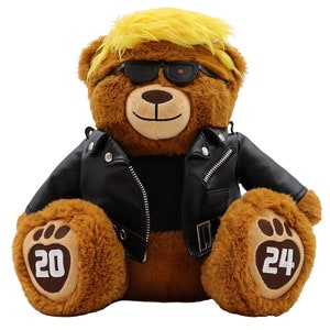 May include: A brown teddy bear wearing a black leather jacket and sunglasses with yellow hair. The bear has the numbers 20 and 24 on its paws.