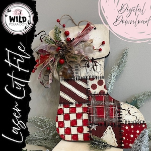 May include: Wooden Christmas stocking decoration with a patchwork design in red and white. The stocking is decorated with a bow, berries, and greenery. The text "Laser Cut File" and "Digital Download" are visible.