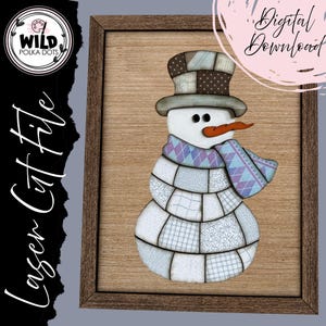 Op de afbeelding: Een houten ingelijste sneeuwman snijbestand. De sneeuwman heeft een patchwork ontwerp met een hoge hoed, sjaal en wortelneus. De afbeelding bevat de tekst "Digital Download" en "Laser Cut File". Het Wild Polka Dots logo staat linksboven.