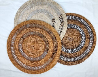 May include: Three woven placemats, one white, one brown, and one with a brown and white pattern. The placemats are made of natural materials and have a circular shape.