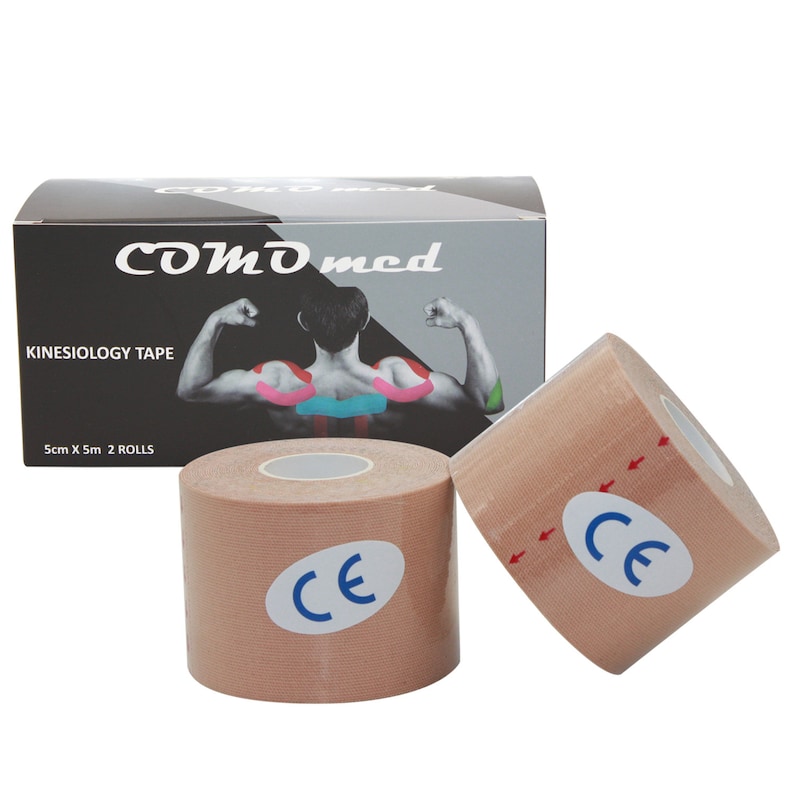 May include: Two rolls of beige kinesiology tape with a blue CE mark. The tape is 5 cm wide and 5 m long. The box is black with white text that reads "COMD med Kinesiology Tape 5cm X 5m 2 ROLLS".