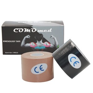 Op de afbeelding: Twee rollen kinesiologietape, een beige en een zwarte, met een CE-markering op elke rol. De tape is 5 cm breed en 5 m lang. De doos is zwart met witte tekst die "COMD med Kinesiology Tape 5cm x 5m 2 ROLLS" luidt.