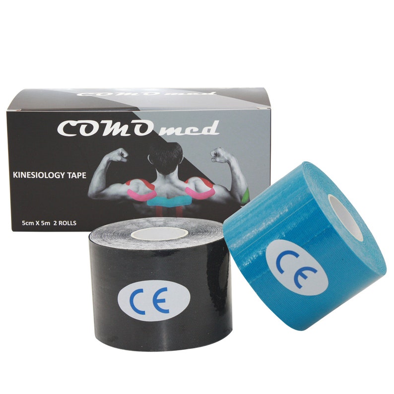Op de afbeelding: Twee rollen kinesiologietape, een zwarte en een blauwe. De tape is 5 cm breed en 5 m lang. De doos heeft de merknaam "COMD med" en de tekst "KINESIOLOGY TAPE" erop gedrukt. De tape heeft een CE-markering.