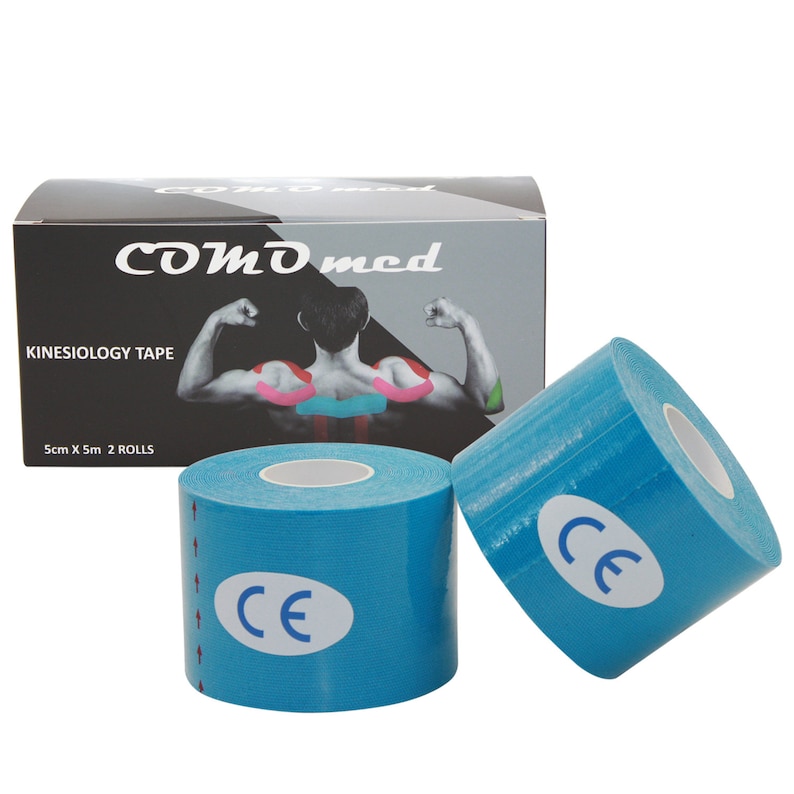 May include: Two rolls of blue kinesiology tape with a white CE mark on each roll. The tape is packaged in a black box with the text "COMD med" and "KINESIOLOGY TAPE" in white. The box also states "5cm X 5m 2 ROLLS".
