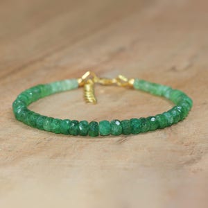 Op de afbeelding: Een groene edelsteen armband met gouden accenten. De armband is gemaakt van kleine, gefacetteerde kralen en heeft een delicate, vrouwelijke uitstraling.