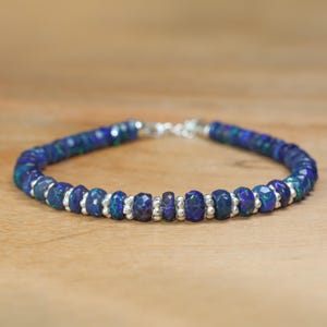 May include: A silver bracelet with dark blue opal beads and silver spacer beads.