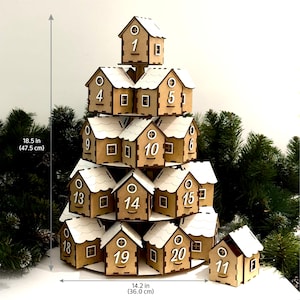 May include: A wooden Christmas advent calendar shaped like a tree with 20 small houses, each with a number from 1 to 20. The houses are stacked in a pyramid shape, with the top house being the smallest and the bottom houses being the largest. The houses are painted brown and have white roofs. The calendar is 18.5 inches tall and 14.2 inches wide.