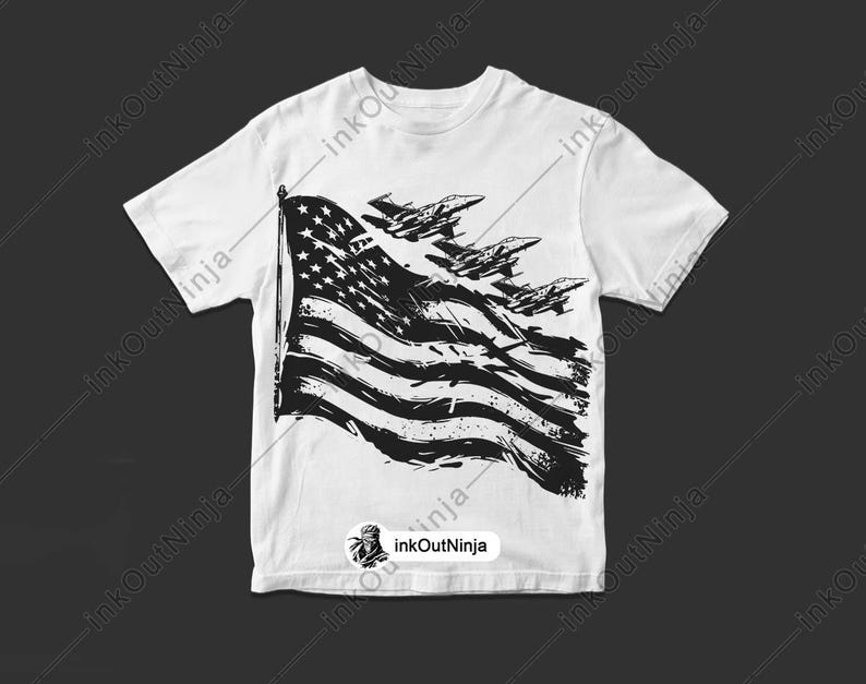 May include: White t-shirt with a black and white graphic of an American flag with fighter jets flying over it.