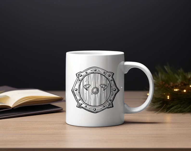 May include: White ceramic mug with a black and white illustration of a shield with a wooden texture. The shield has a circular center with a small circle in the middle and two small triangles on either side.