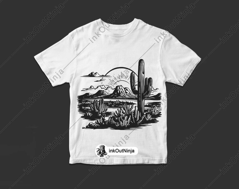 May include: A white t-shirt with a black and white illustration of a desert landscape with a large cactus in the center. The sun is setting behind the mountains in the background.