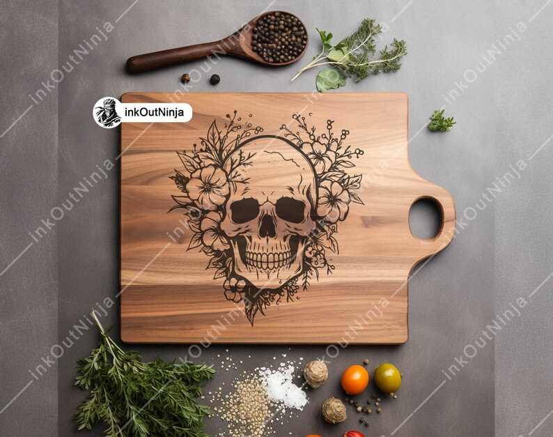 May include: A wooden cutting board with a hand-carved design of a skull with flowers. The board has a handle on the side.